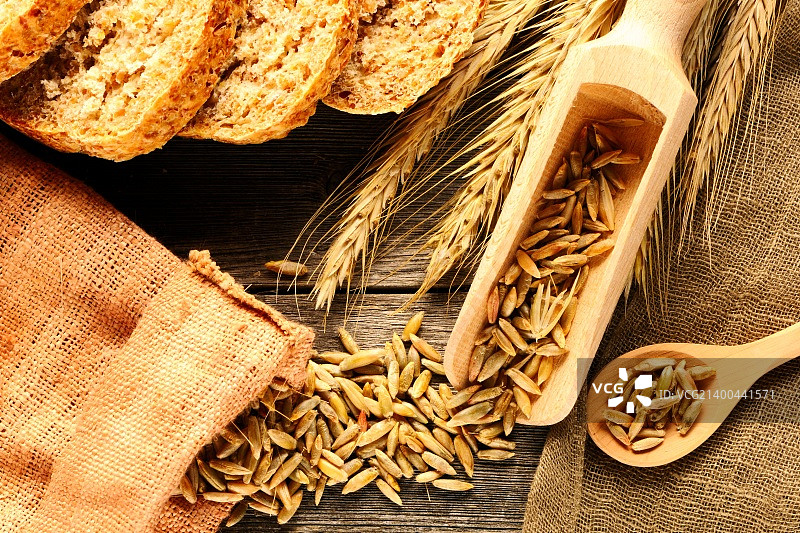 在木制背景上的黑麦小穗和切片面包图片素材