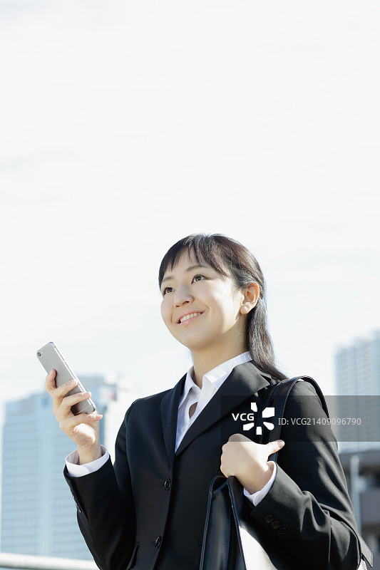 日本年轻女商人与电话在东京市中心图片素材