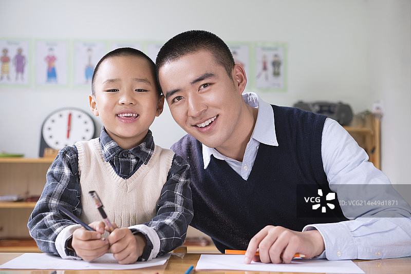 Kindergarten teacher and boy writing图片素材