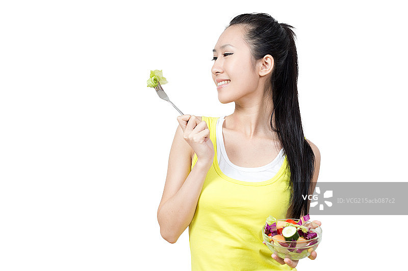 年轻女孩吃水果和蔬菜图片素材