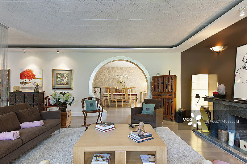 Living room with dining area seen through circular wall in background at contemporary home图片素材