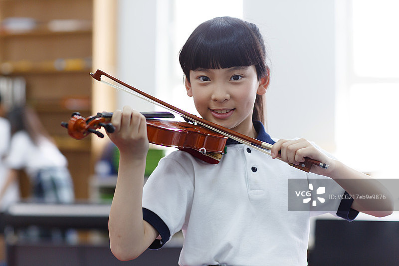 小学女生在拉小提琴图片素材