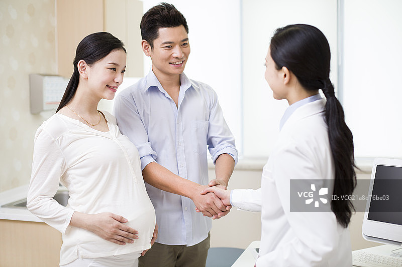 孕妇的丈夫和医生握手图片素材
