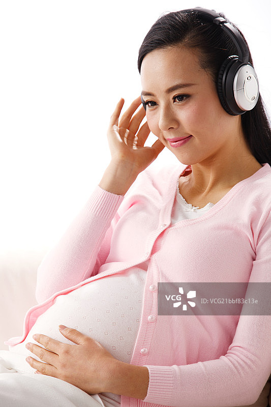 孕妇坐在沙发上听音乐图片素材