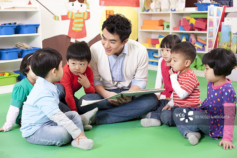 幼儿园老师和小朋友一起看图书图片素材