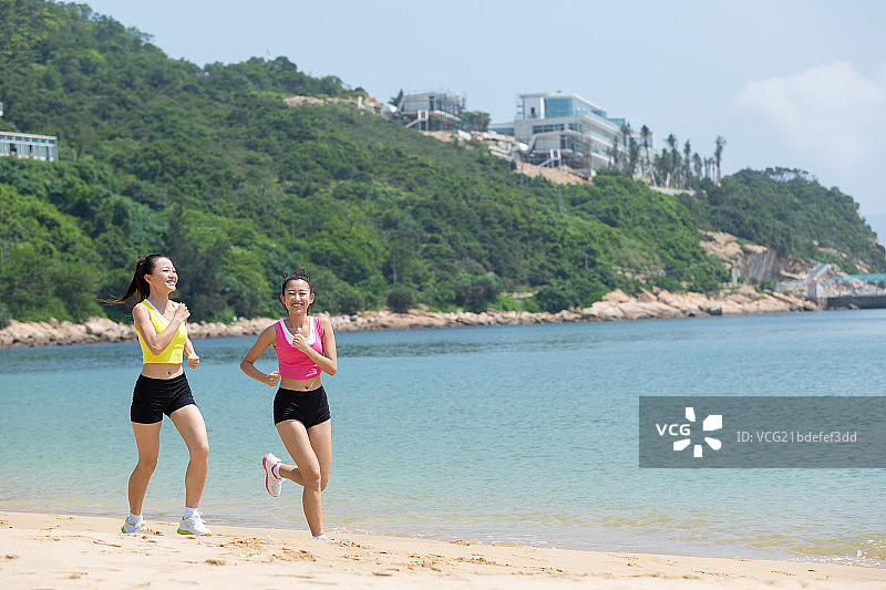 两个女孩在海边跑步图片素材