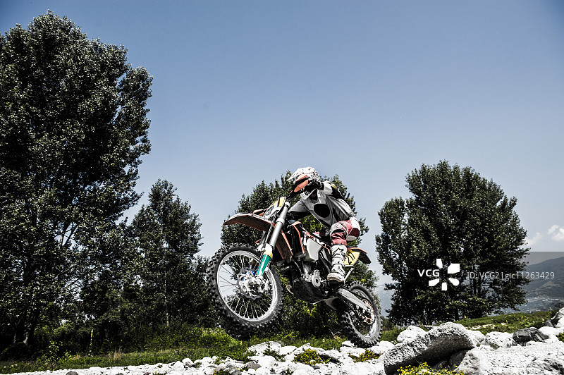 在意大利乡村骑摩托车越野的年轻人图片素材