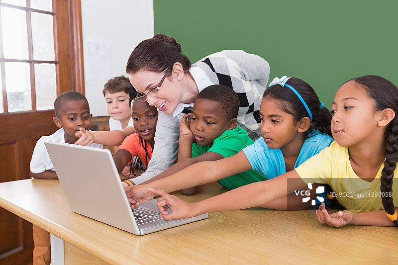老师和学生看着笔记本电脑在小学图片素材