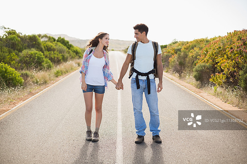 全程徒步的年轻夫妇站在乡间小路上图片素材