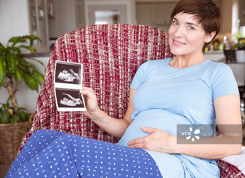 孕妇在家客厅看超声波扫描图片素材