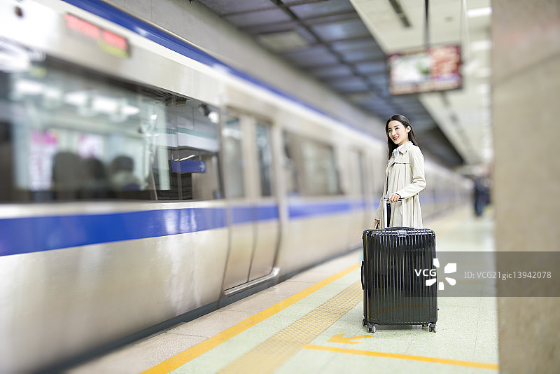 Businesswoman waiting for train at subway station图片素材
