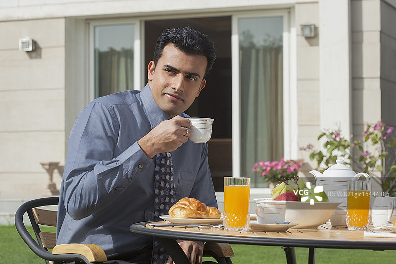 印度，商人在花园里吃早餐图片素材
