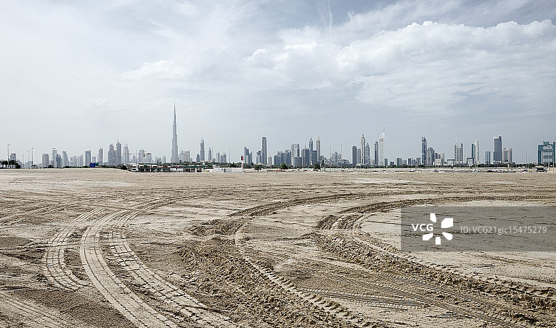 越野车试车沙泥地和迪拜摩天大楼远景图片素材