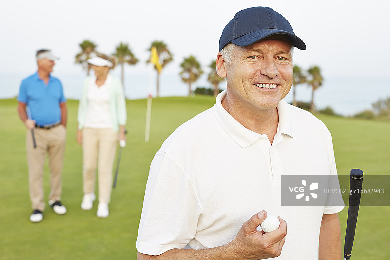 在高尔夫球场上微笑的老人图片素材