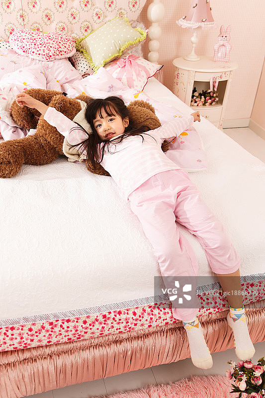 可爱的小女孩躺在床上图片素材