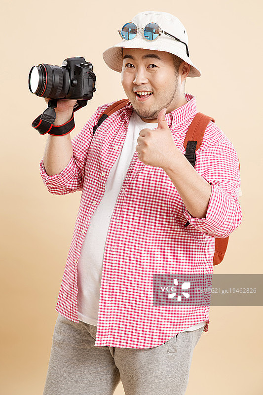 肥胖的青年男人拿着相机图片素材