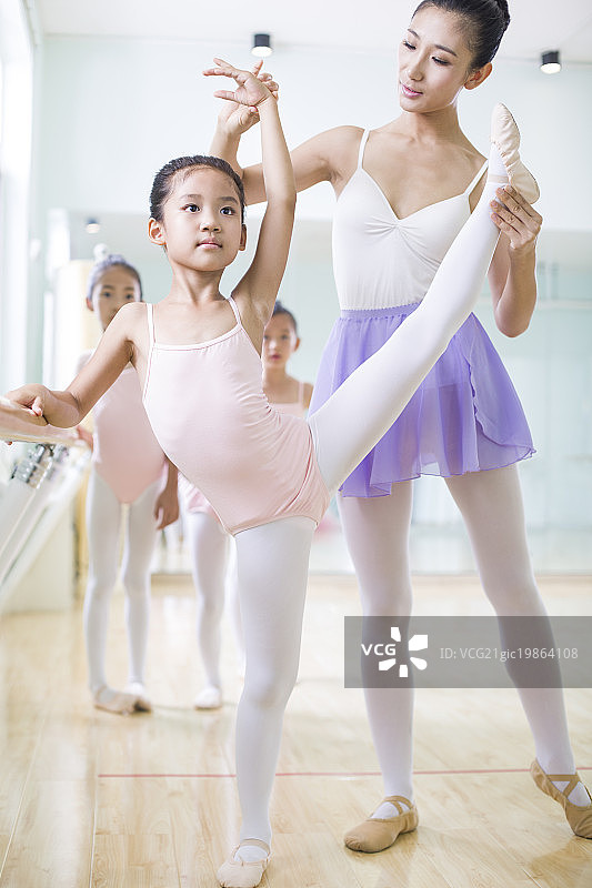 年轻舞蹈老师教小女孩跳芭蕾图片素材