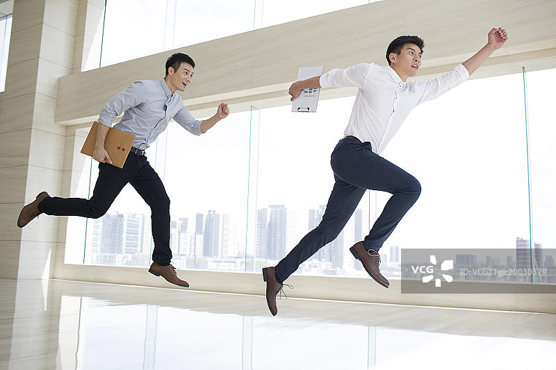年轻商务男子在办公楼里奔跑图片素材