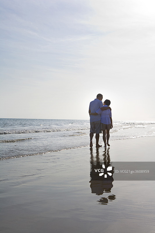 老年夫妇在沙滩上散步图片素材