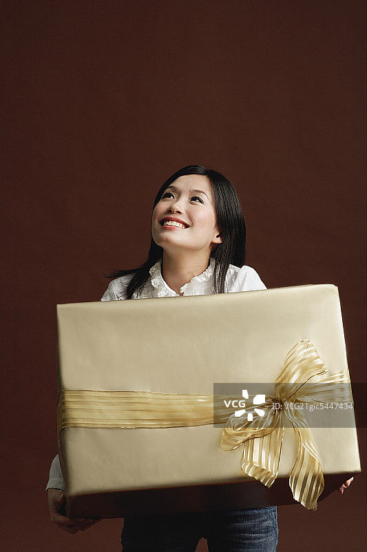 女人拿着礼物包装的金盒子图片素材