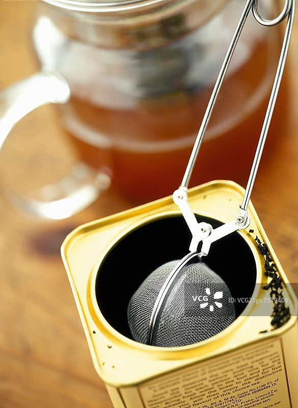 茶叶装于带滤茶器和玻璃茶壶中图片素材