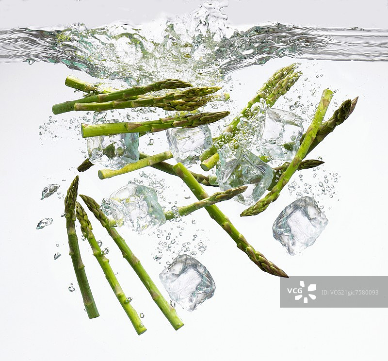 绿芦笋和冰块落入水中图片素材