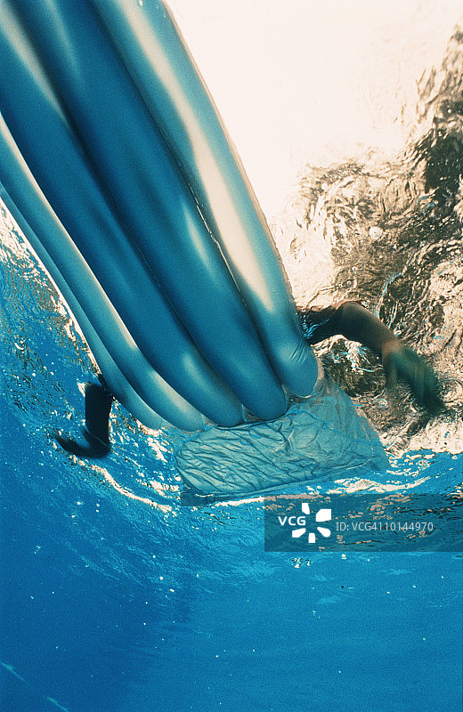 游泳者在水面上划动充气床垫，从下面看，颜色图片素材