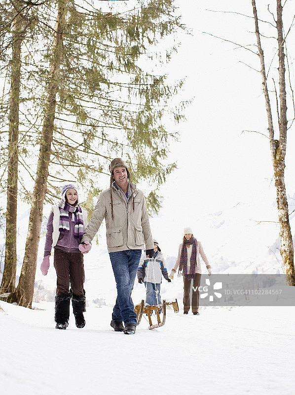 一家人在雪地里拉雪橇图片素材