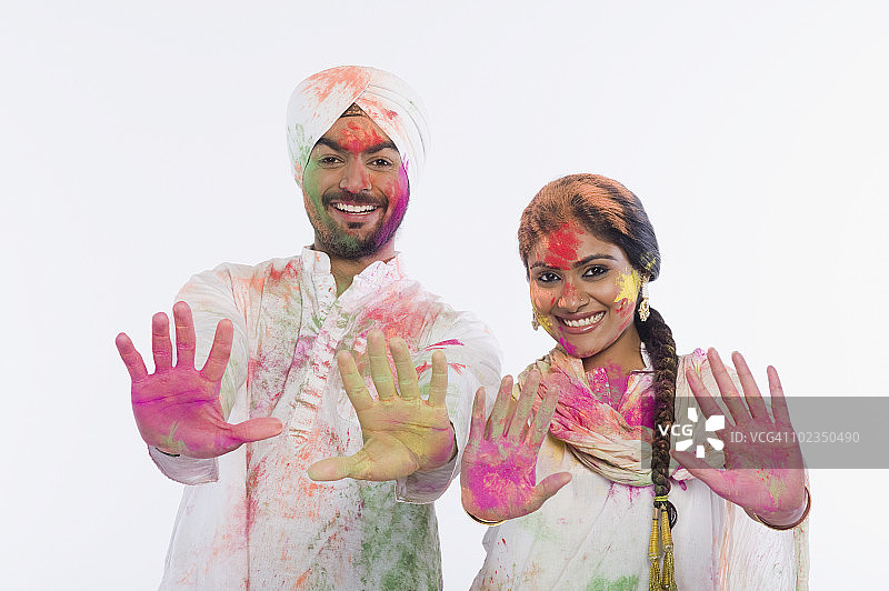 庆祝胡里节时，一对夫妇举起他们彩色的手图片素材