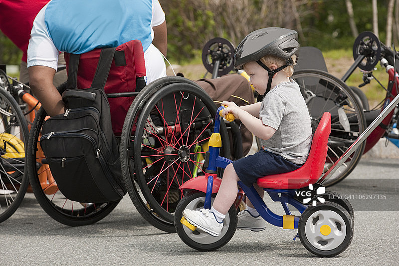 有脊髓损伤的老兵和有关节问题的男孩准备无障碍的自行车比赛图片素材