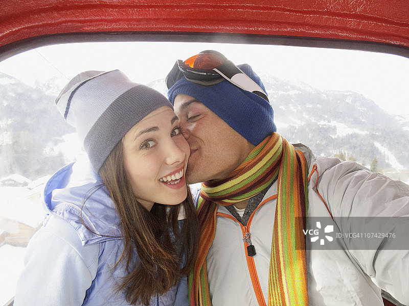 男人在滑雪缆车上亲吻妻子图片素材
