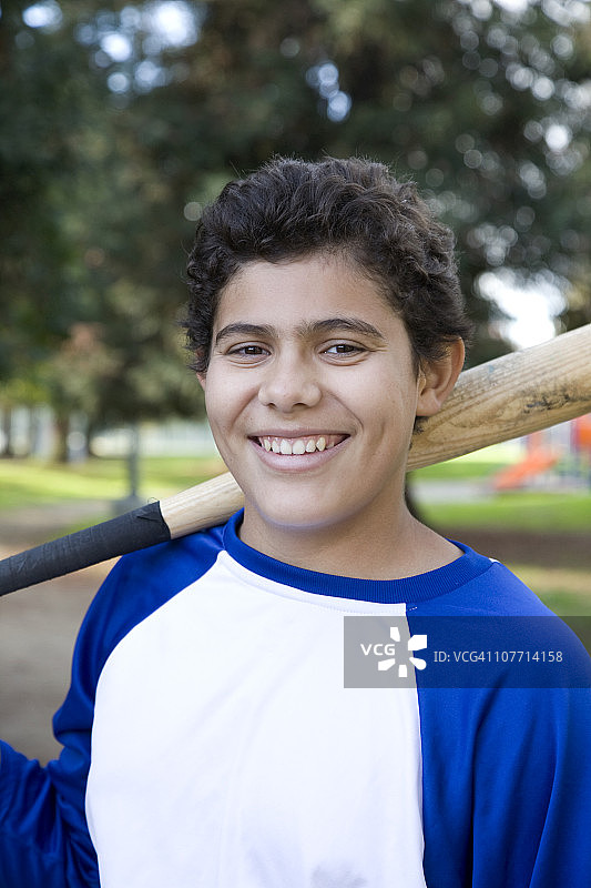 西班牙裔少年拿着棒球棒图片素材