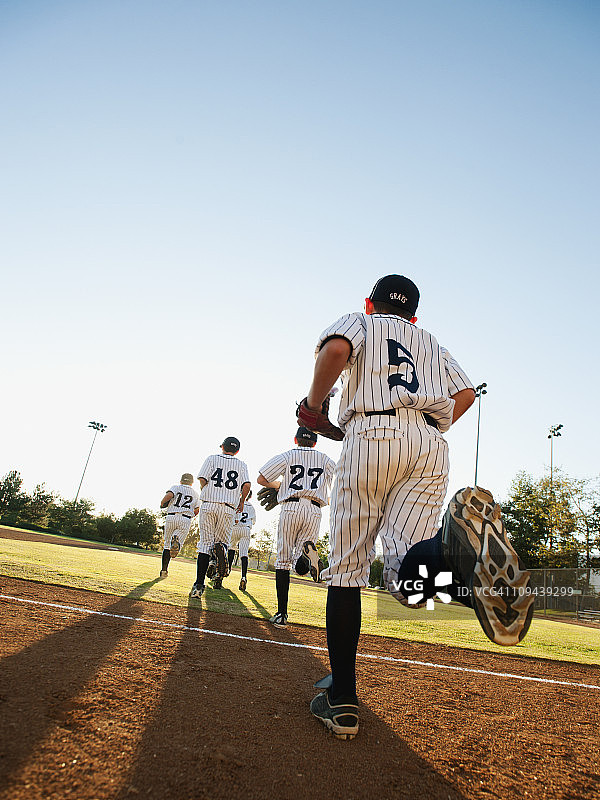 棒球运动员(10-11人)在棒球场地上奔跑图片素材