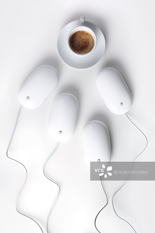 电脑鼠标环绕咖啡杯，白色背景图片素材