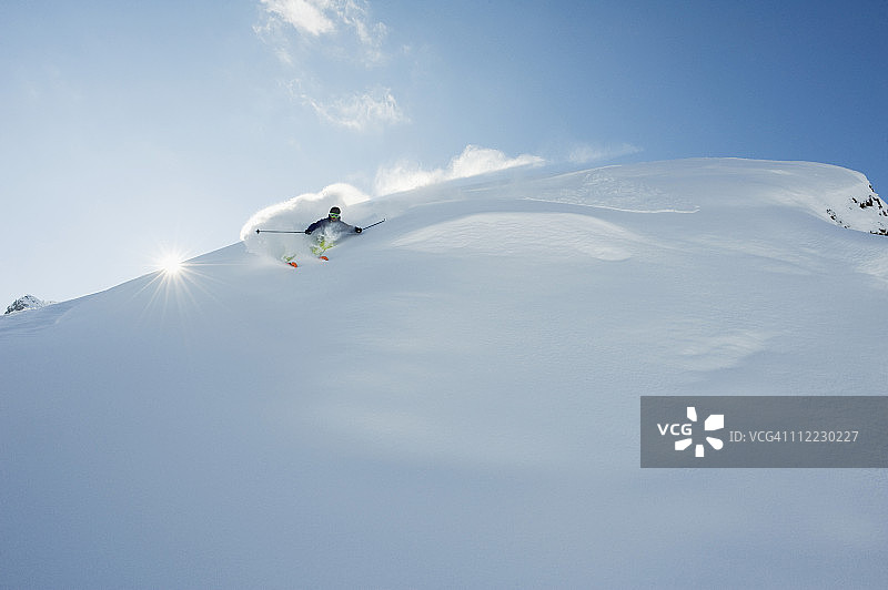 奥地利，一名男子在积雪覆盖的阿尔伯格山上滑雪图片素材