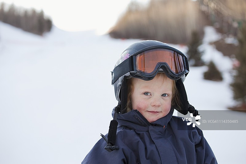 一个戴着头盔和滑雪面罩的小男孩图片素材