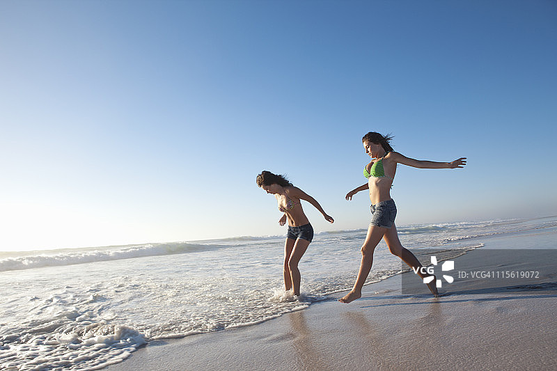 两个女孩在沙滩上奔跑图片素材