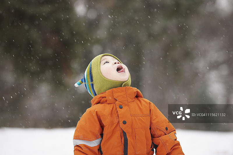 一个中国男孩用舌头接雪花图片素材