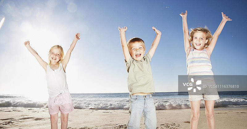 孩子们在海滩上举着手图片素材