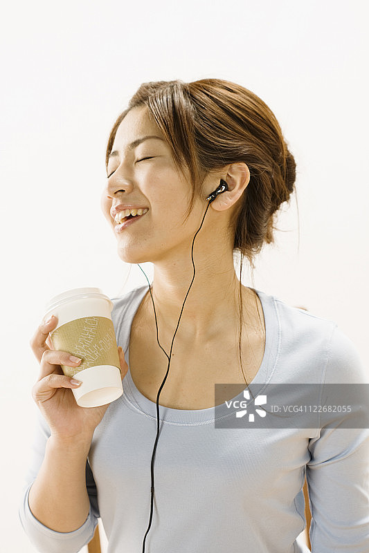 边喝咖啡边听音乐的女人图片素材