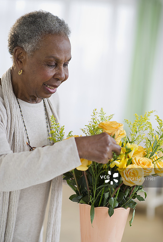 一名黑人妇女在花瓶中插花图片素材