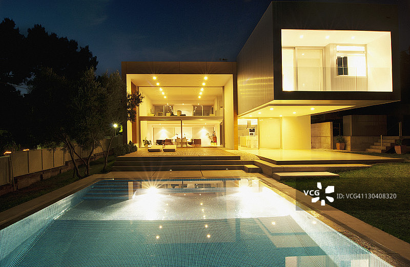 晚上在现代化的房子外面的游泳池图片素材
