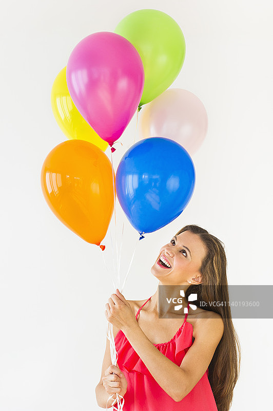 微笑的女人拿着气球，在摄影棚拍摄图片素材