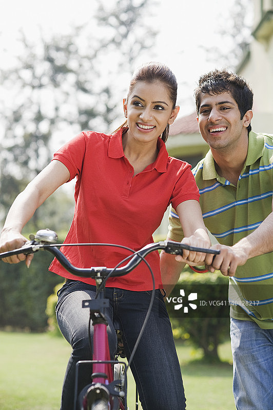 一个骑自行车的男人扶着一个女人图片素材