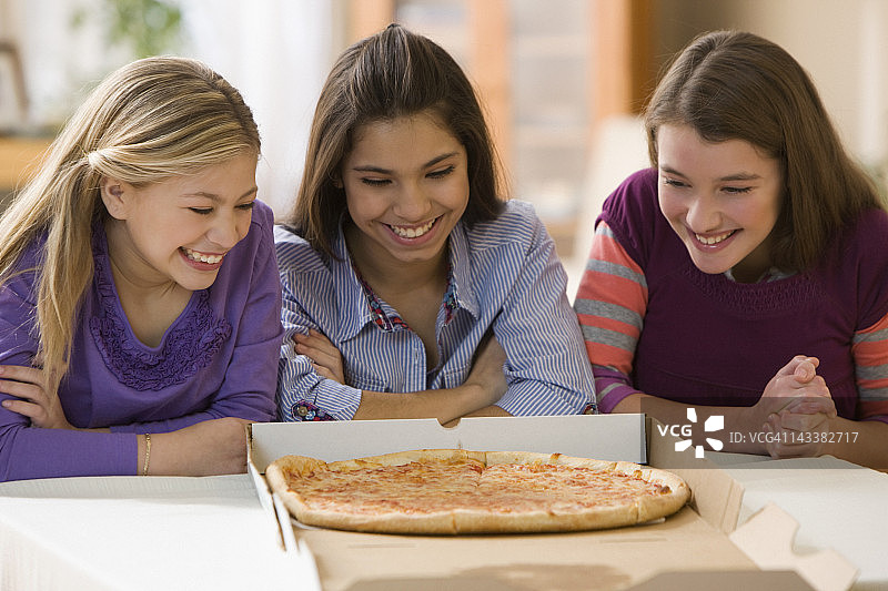 饥饿的女孩在看披萨图片素材