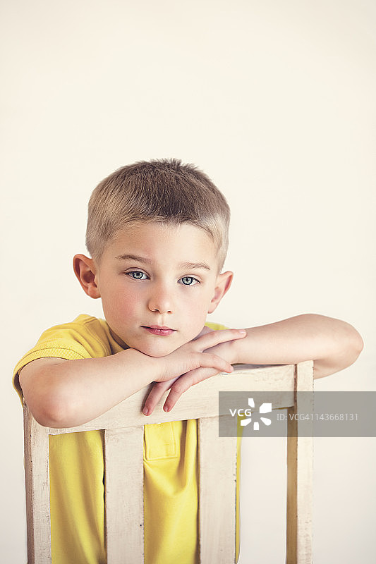 坐在椅子上的蓝眼睛金发男孩图片素材