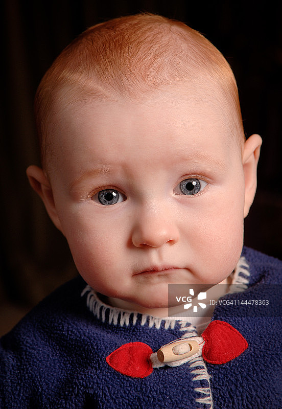 一个红发婴儿的肖像，注视着他图片素材