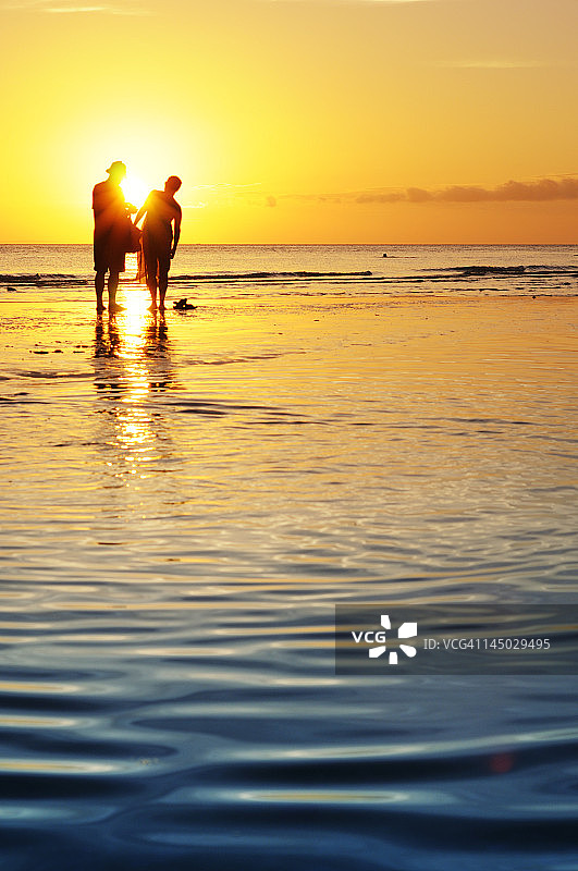 海滩上最后一缕阳光下的情侣图片素材