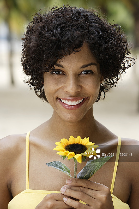 女人捧着黄色的向日葵微笑着图片素材