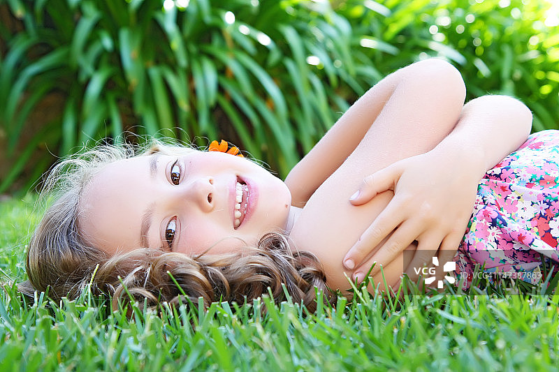年轻女孩躺在草地上图片素材